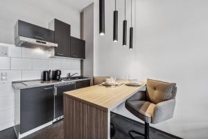 a kitchen with a wooden table and a chair at Erba Retreat! Barrierefreies, modernes 1-Zimmer-Appartement in optimaler Lage! in Bamberg