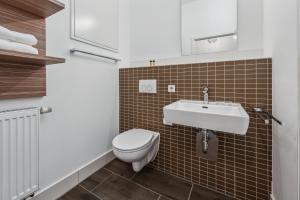 a bathroom with a toilet and a sink at Erba Retreat! Barrierefreies, modernes 1-Zimmer-Appartement in optimaler Lage! in Bamberg