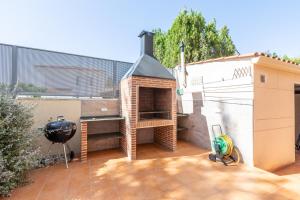 - un barbecue sur une terrasse à côté d'un bâtiment dans l'établissement Casa junto al mar con jardín, à Sagonte