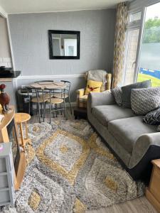 a living room with a couch and a table at Woodlands Pheasant Chalet, Bideford Bay in Bideford