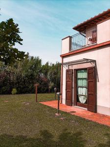 ein Haus mit einem Balkon und einer Tür mit einem Fenster in der Unterkunft Il Casale di David in Pontedera