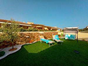 einen Hof mit zwei Stühlen und einem Grastisch in der Unterkunft Villa al mare - I CORALLI in Valledoria