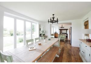 uma sala de jantar com uma mesa de madeira e cadeiras em Charming 5BR Farmhouse Retreat in Amersham em Amersham