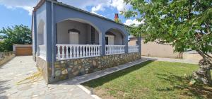 a blue house with a stone wall and a yard at Fertoun apartment in Chaïdeftón