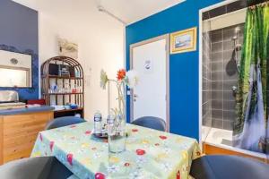 a dining room with a table with chairs and a tub at Appartement confortable avec cuisine salon salle de bains in Anhée +25 photos