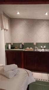 a bathroom with a sink and a bed with towels at Casa Kuhstall in La Cumbrecita +55 photos