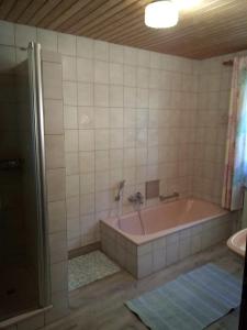 a bathroom with a pink tub and a shower at Leitingerhof in Thalgau