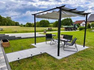 a gazebo with a table and chairs on a patio at Ferienwohnung Storchennest in Eisfeld