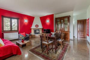 a living room with red walls and a table at Villa Tra Vigne e Stelle in Neive
