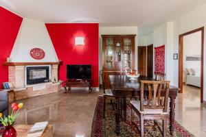 a living room with a red wall at Villa Tra Vigne e Stelle in Neive
