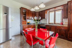 a kitchen with a red dining table and red chairs at Villa Tra Vigne e Stelle in Neive
