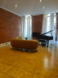 een woonkamer met een bank en een piano bij Versailles in Nottingham