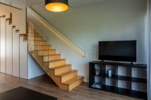 uma sala de estar com uma escada e uma televisão em Weekend apartment em Sigulda