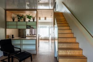 uma escada que leva a uma cozinha com uma cadeira em Weekend apartment em Sigulda