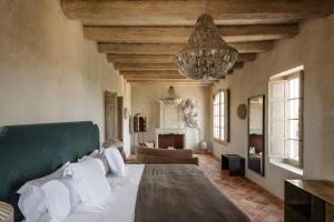 a bedroom with a large bed and a living room at Vestige Son Vell in Ciutadella