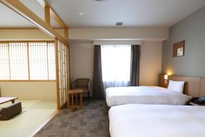 Postel nebo postele na pokoji v ubytování Dormy Inn Chiba City Soga