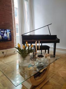 a glass table with a piano in a living room at Versailles in Nottingham