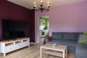 a living room with a couch and a flat screen tv at farbenfrohe Ferienwohnung in Detmold