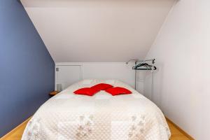 um quarto com uma cama com almofadas vermelhas em Magnifique petit appartement tout équipé, silencieux em Anhée