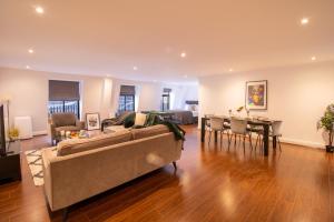 ein Wohnzimmer mit einem Sofa und einem Tisch in der Unterkunft Luxurious Apartments in Mayfair in London