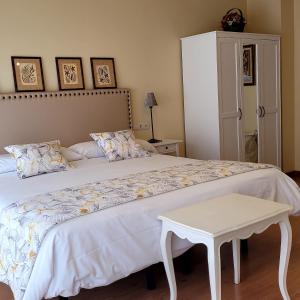 a bedroom with a large white bed with a table at CasaMarichelvas in San Asensio
