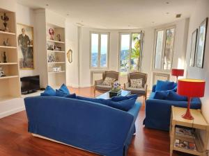a living room with blue couches and a red lamp at Villa Bethanie in Villefranche-sur-Mer