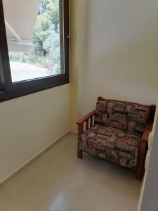 a couch sitting in a room with a window at EPavli Xenia Pefkochori-Paliouri 30m in Paliouri