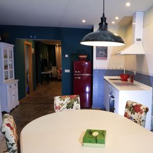 a kitchen with a white table with chairs and a red refrigerator at CasaMarichelvas in San Asensio
