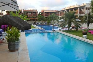 uma grande piscina azul ao lado de um edifício em Qavi - Pipa Beleza Resort em Pipa