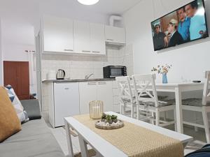a kitchen and living room with a table and a tv at Vacation House Rental 20m From the Beach in Gerakini