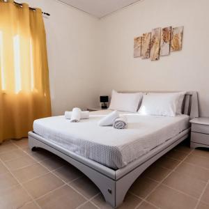 a bedroom with a large bed with white sheets at Villa Vedema in Kissamos in Kissamos