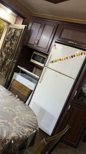 a white refrigerator with magnets on it in a kitchen at شقه مفروشه مع حديقه اربد بجانب مدارس دار العلوم in Irbid