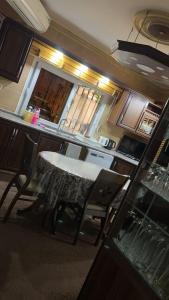 a kitchen with a table and chairs in a room at شقه مفروشه مع حديقه اربد بجانب فندق فلامنجو ومدارس دار العلوم in Irbid