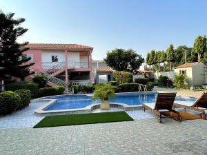 a swimming pool with a chair and a house at Residencial Ru-B in Luanda