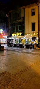 zwei weiße Regenschirme vor einem Gebäude in der Nacht in der Unterkunft Gold Apartament in Olsztyn + 7 Fotos