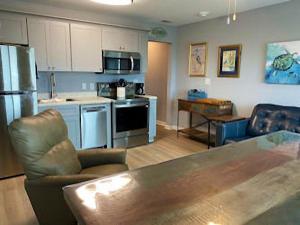 a kitchen and living room with a couch and a table at Gulf Shores Plantation Condos in Gulf Shores