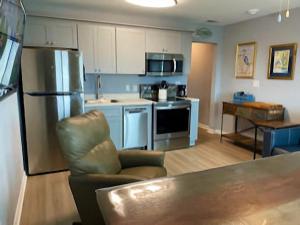a kitchen with a refrigerator and a chair in it at Gulf Shores Plantation Condos in Gulf Shores