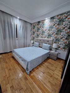 1 dormitorio con cama grande y pared de flores en Morocco House en Casablanca