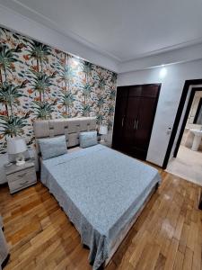 una camera con un grande letto e una parete floreale di Morocco House a Casablanca