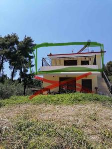 a house on top of a hill with a sign at EPavli Xenia Pefkochori-Paliouri 30m in Paliouri