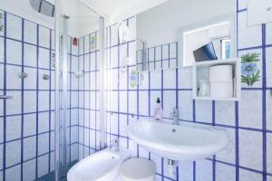 un bagno blu e bianco con lavandino e servizi igienici di Hotel Danieli a Lido di Jesolo