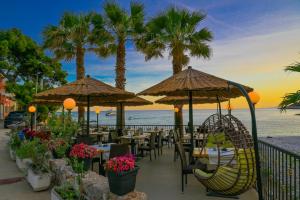 un restaurante en la playa con mesas y sombrillas en Hotel Fortuna en Hvar