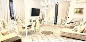 ein Wohnzimmer mit einem Tisch, Stühlen und einem Kronleuchter in der Unterkunft Villa near Milan & Rho Fiera in Gaggiano