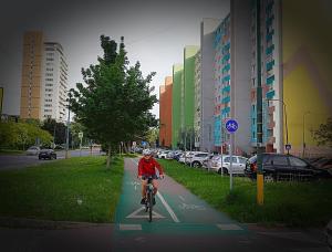 a person is riding a bike on a sidewalk at Dominant Suite Studio Hostel in Bratislava