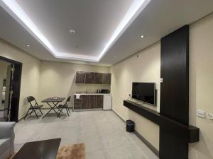 een woonkamer met een televisie en een keuken bij شقق درر رامه للشقق المخدومة 11 in Riyad