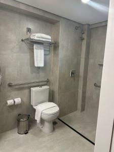 a bathroom with a toilet and a shower with towels at SAN MARINO SUITES HOTEL By NOBILE in Goiânia