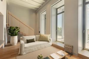 a living room with a white couch and windows at Vandoma Serviced Apartments in Porto