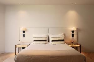 una camera da letto con un letto grande con due tavoli di Vandoma Serviced Apartments a Porto Altre 43 foto