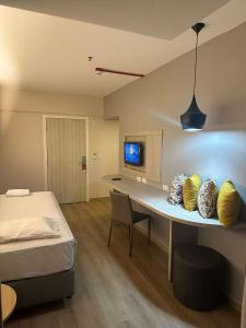 SAN MARINO SUITES HOTEL By NOBILE في غويانيا: غرفة نوم بها مكتب وسرير وغرفة بها سرير نقّال