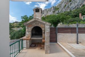 Un horno de pizza al aire libre con una montaña al fondo en Apartment Marina on the second floor, en Makarska